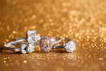 three diamond rings on a sparkling gold background
